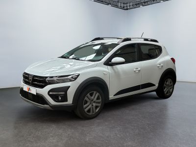Une voiture blanche est garée dans une pièce blanche au sol noir.