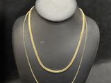 two necklaces on a mannequin stand next to each other