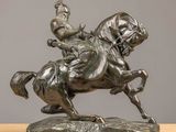 bronze statue of a man on a horse with a crown on his head