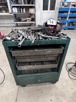 un chariot à outils vert rempli d'outils dans un garage