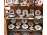 de nombreuses assiettes et tasses sur les étagères du placard