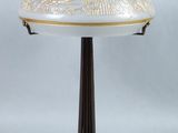 a white and gold table lamp with a glass shade on it