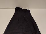 a black skirt sitting on top of a white shelf next to a pair of shoes
