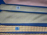four different colored ties are lined up on a blue surface