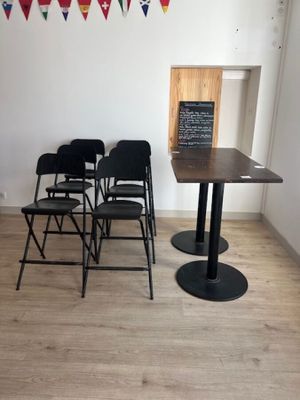 des tables et des chaises dans une pièce où des drapeaux sont accrochés au mur