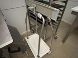 une cuisine avec un chariot métallique au milieu de la pièce