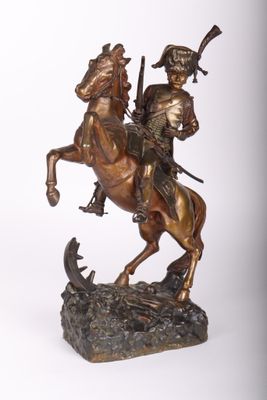 statue en bronze représentant un homme à cheval, avec un fusil sur le dos