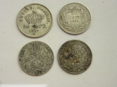 quatre pièces de monnaie britanniques différentes posées sur une surface blanche