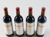 three bottles of red wine are lined up on a white surface