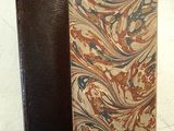 un gros plan d'un livre à la couverture marron posé sur une table