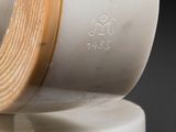 a close up of a white vase with a wooden edge