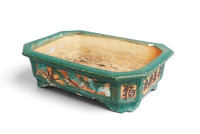 a small green planter that is sitting on a white surface