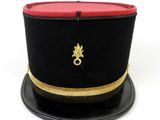 black and red hat with gold trim on top of a black plate