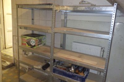 a metal shelving in the corner of a room with shelves
