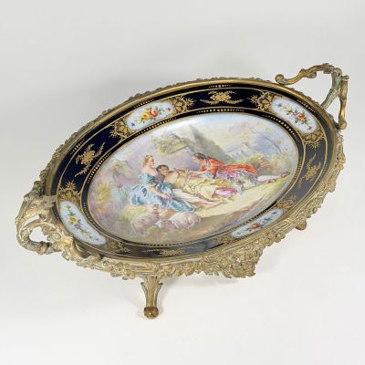 a decorative tray with a painting on it on a stand
