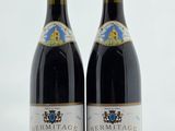 deux bouteilles de vin posées sur une table l'une à côté de l'autre