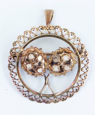 an image of a gold pendant with three flowers inside of it