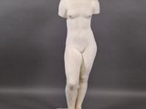 a white marble statue of a woman standing on a square base