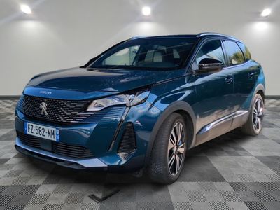 la voiture bleue est garée sur le sol en damier d'un garage