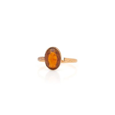 Gros plan sur une bague en or avec une pierre orange