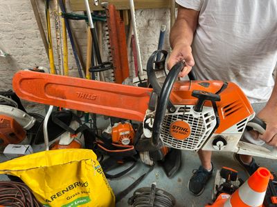 a man that is holding a chainsaw in his hand
