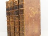 three old books stacked on top of each other on a white surface