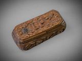 an old wooden box with carvings on it sitting on a table