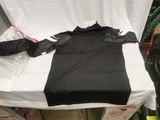 a black t - shirt on a white bed in a room