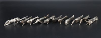 a close up of a bunch of metal birds on a black surface