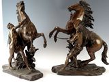une paire de sculptures en bronze représentant un homme à cheval et une femme à cheval