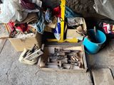 a box of tools sitting on the ground next to a pile of other items