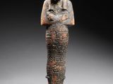 an egyptian statue of a woman holding a bird