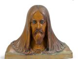 statue of a man with long hair and a beard on a wooden base