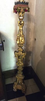 une horloge en or posée sur un socle dans un coin de la pièce