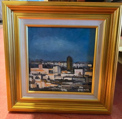 tableau représentant une vue de ville, dans un cadre doré, sur un fond rose