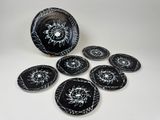 a group of black and white plates sitting on top of a table