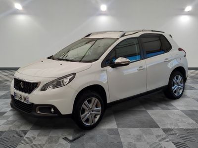 la voiture blanche est garée sur un sol en damier dans le garage