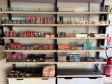 un rayon de produits de maquillage dans un magasin, avec un extincteur