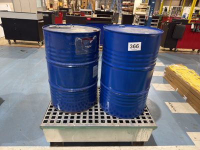 deux fûts bleus posés sur une palette dans un entrepôt