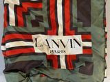 a close up of a blanket on a table with a tag on it