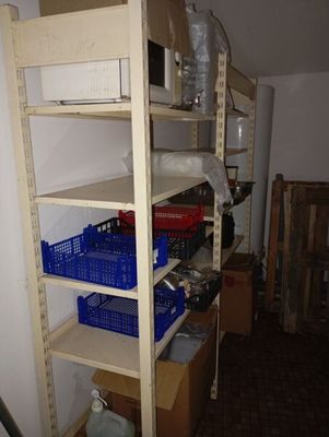 a shelf with baskets and containers on it in a room