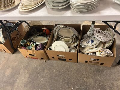 de nombreuses boîtes remplies d'assiettes et de bols sur la table