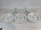 six assiettes en verre transparent posées sur une table blanche