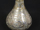 a silver vase with a gold decoration on it