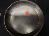 a metal pan that has a red sticker on it