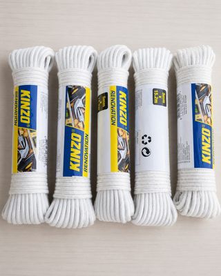 Trois cordons blancs de type « paracord » sont disposés sur une table