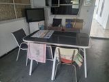 une table et des chaises dans une pièce équipée d'une télévision