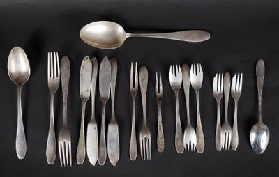 de nombreuses fourchettes et cuillères disposées sur une surface noire