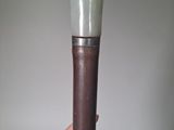 a close up of a person ' s hand holding a brown and white vase