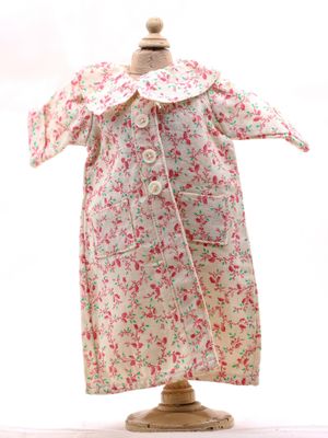 robe à fleurs rose et blanche posée sur un présentoir pour mannequin